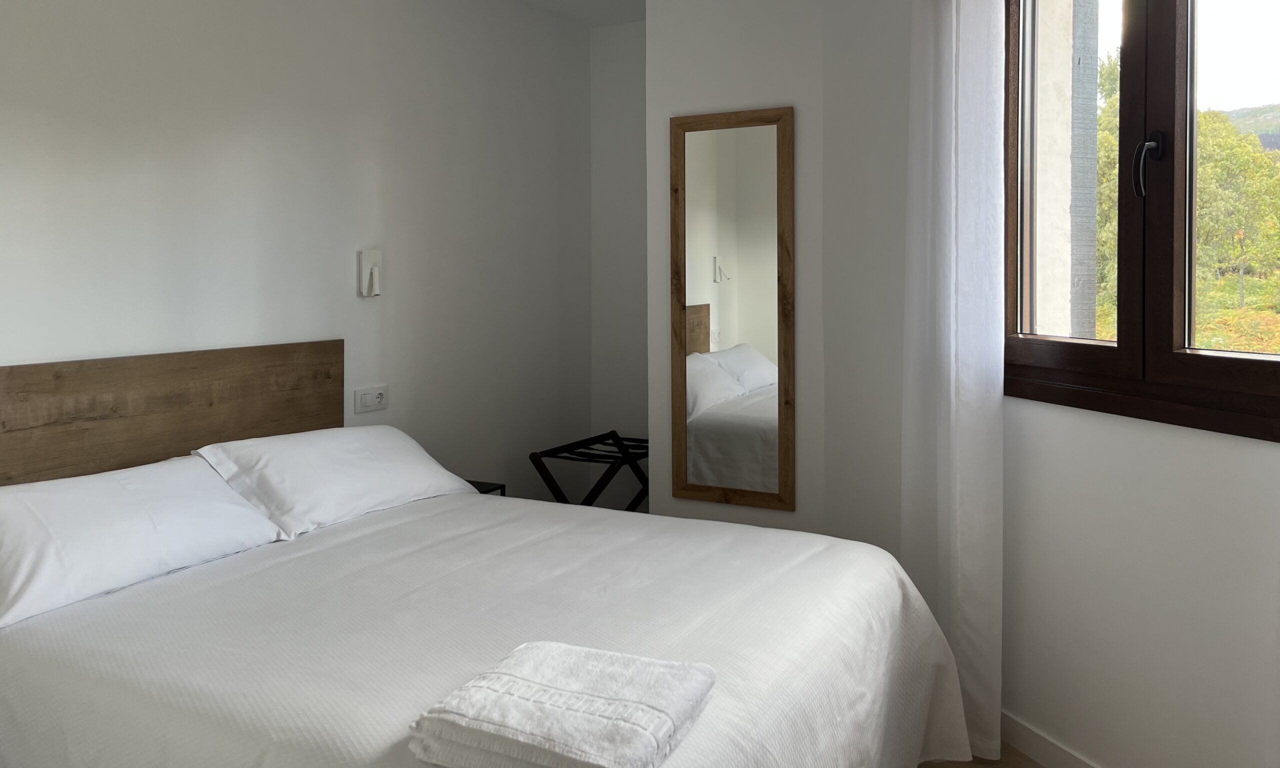 Dormitorio con cama de matrimonio y vistas a la sierra – Apartamentos Tres Olivos