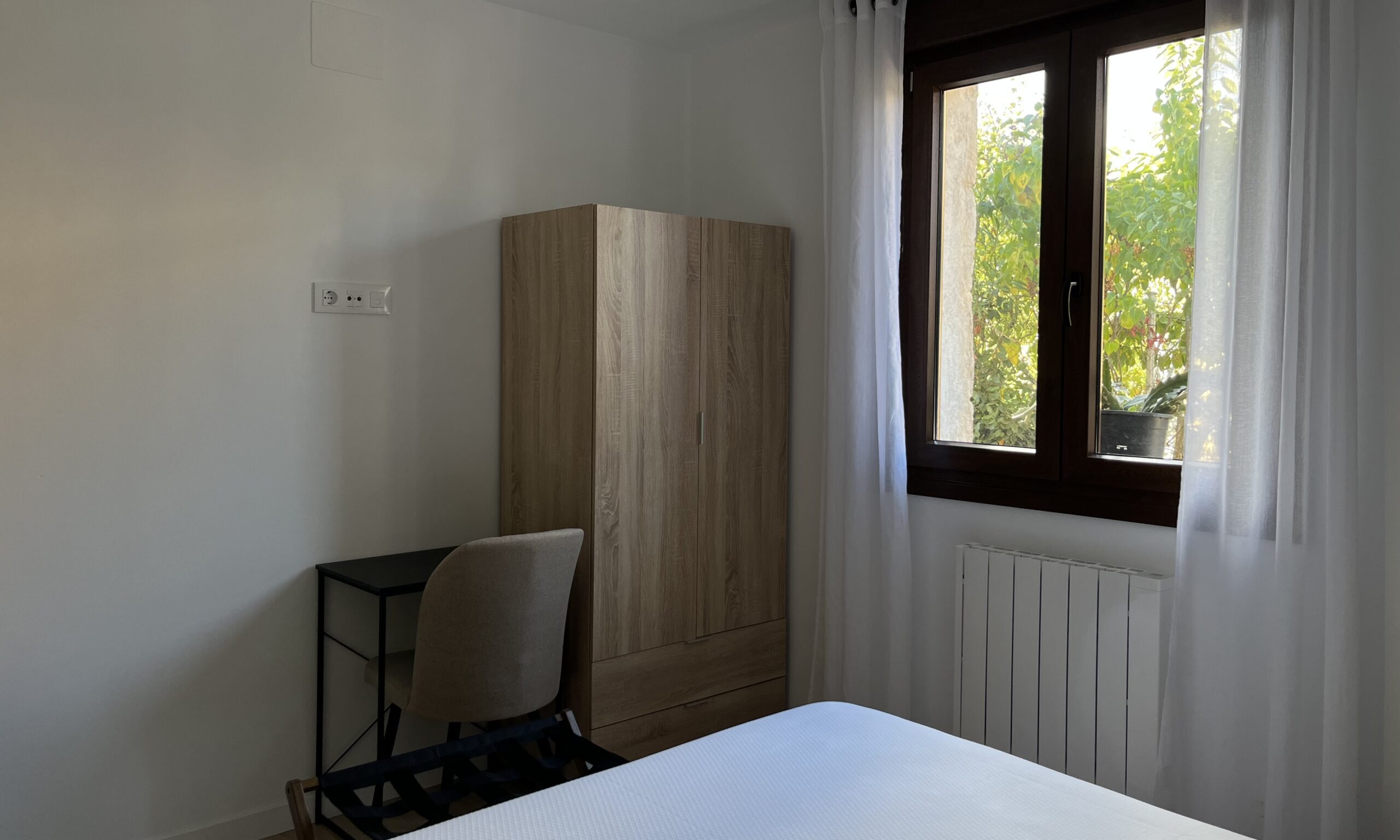 Dormitorio con cama de matrimonio y vistas a la sierra – Apartamentos Tres Olivos