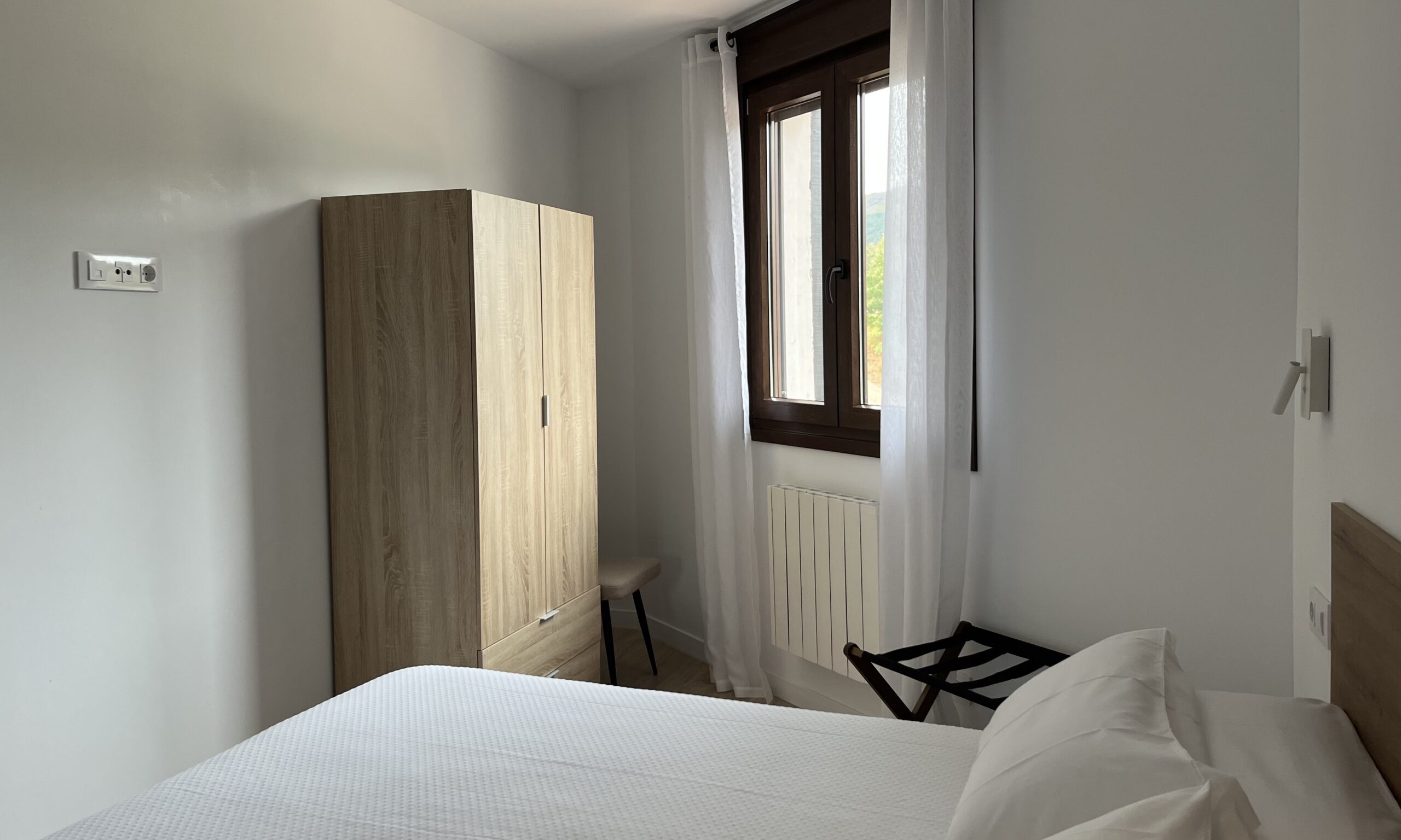 Dormitorio con cama de matrimonio y vistas a la sierra – Apartamentos Tres Olivos